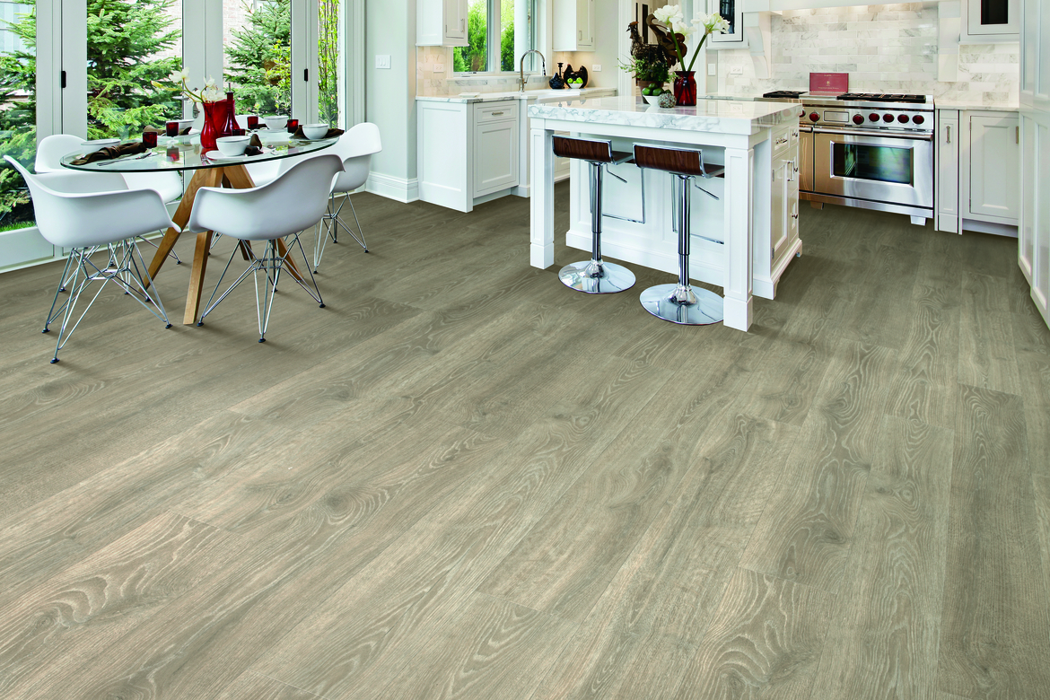 Laminate flooring in a kitchen and dining area with white cabinetry
