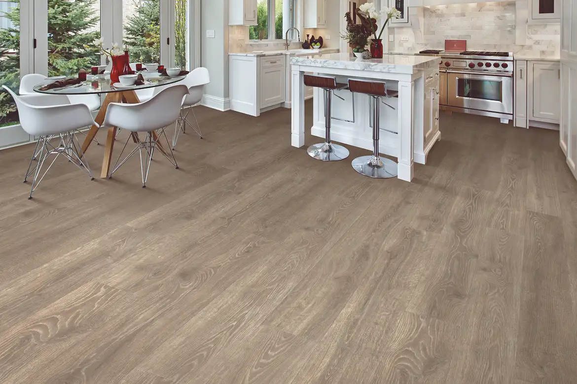 Laminate flooring in a kitchen and dining area with white cabinetry